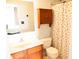 Modest bathroom features a cherry patterned shower curtain, matching cabinets, and white sink at 9718 Jupiter Pass, Carmel, IN 46032