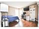 Modern bedroom features hard wood floors, desk, mounted TV, and bright natural light from the double windows at 9718 Jupiter Pass, Carmel, IN 46032