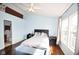 A modern bedroom features a vaulted ceiling, dark wood floors, and bright natural light from the double windows at 9718 Jupiter Pass, Carmel, IN 46032