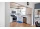 Well-lit kitchen featuring white cabinets, stainless steel appliances, and hardwood flooring at 9718 Jupiter Pass, Carmel, IN 46032