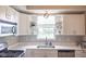 Bright kitchen features white cabinetry, stainless steel appliances, a large window, and stylish decor at 9718 Jupiter Pass, Carmel, IN 46032