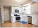 Modern kitchen with stainless steel appliances, white cabinets, and hardwood floors at 9718 Jupiter Pass, Carmel, IN 46032