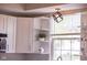 Close up of kitchen cabinets, modern light fixture, window and sink at 9718 Jupiter Pass, Carmel, IN 46032