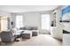Bright and open living area featuring a sectional sofa, fireplace and natural light at 9718 Jupiter Pass, Carmel, IN 46032