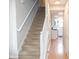 Carpeted staircase with white railing leads to the upper level; kitchen in background at 9718 Jupiter Pass, Carmel, IN 46032