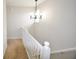 Clean staircase with white railings leading to the upper level of the home, illuminated by a modern light fixture at 9718 Jupiter Pass, Carmel, IN 46032