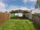 Backyard with a metal carport featuring grassy areas and wood fence at 1035 Albany St, Indianapolis, IN 46203