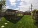 Spacious backyard featuring a metal carport structure, grassy area and wood fence at 1035 Albany St, Indianapolis, IN 46203