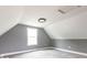 This attic bedroom features neutral walls, carpeted floors, and a window at 1035 Albany St, Indianapolis, IN 46203