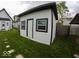 This backyard shed features white siding, a black roof, and is well-lit by windows at 1035 Albany St, Indianapolis, IN 46203