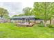 Exterior view of house from backyard showing large deck with outdoor seating and grassy lawn at 10805 Charlemagne Dr, Indianapolis, IN 46259