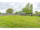 Large grassy backyard with mature trees and wooden fence at 10805 Charlemagne Dr, Indianapolis, IN 46259