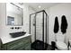 Modern bathroom features a black framed shower, green vanity, and marble-look tile at 10805 Charlemagne Dr, Indianapolis, IN 46259