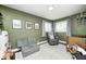 Green toned room includes gray sofa, chair, rug and crib with natural light at 10805 Charlemagne Dr, Indianapolis, IN 46259