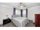 Comfortable bedroom featuring hardwood floors, ceiling fan, natural light, and modern decor at 10805 Charlemagne Dr, Indianapolis, IN 46259
