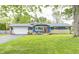 Charming single-story home with a blue exterior, a stone accent wall and mature landscaping at 10805 Charlemagne Dr, Indianapolis, IN 46259