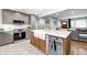 Open kitchen with a farmhouse sink, wooden cabinets on the island, stainless steel appliances and grey cabinets at 10805 Charlemagne Dr, Indianapolis, IN 46259