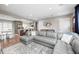 Spacious living room with gray sectional and opens to kitchen featuring stylish decor and lots of natural light at 10805 Charlemagne Dr, Indianapolis, IN 46259