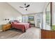Bright bedroom featuring a large bed with red bedding, ceiling fan, and natural light at 1105 Wild Ridge Blvd, Brownsburg, IN 46112