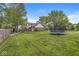 Large backyard featuring a trampoline, playground, and fenced yard at 1106 Fox Trail W Dr, New Palestine, IN 46163