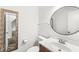 Cozy half bathroom with a single sink vanity and round mirror at 1106 Fox Trail W Dr, New Palestine, IN 46163