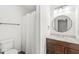 Bathroom featuring a toilet, tub with shower, and updated vanity with a round mirror at 1106 Fox Trail W Dr, New Palestine, IN 46163