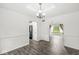 Open dining room with hardwood flooring, large windows, and connects to a kitchen area at 1106 Fox Trail W Dr, New Palestine, IN 46163
