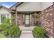 Inviting front porch with brick detail, a cozy bench, and a hanging flower basket at 1106 Fox Trail W Dr, New Palestine, IN 46163
