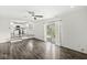 Bright living room with ceiling fan, wood floors, and sliding glass doors to backyard, adjacent to open kitchen at 1106 Fox Trail W Dr, New Palestine, IN 46163