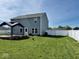 Spacious backyard featuring a deck with a pergola, a well-maintained lawn, and a white privacy fence at 1112 W Nature Pointe Ln, Muncie, IN 47304