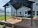 Backyard view with deck, pergola with lighting, outdoor table and chairs, and privacy fence at 1112 W Nature Pointe Ln, Muncie, IN 47304
