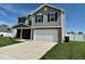 Two-story home with gray siding, brick accents, manicured lawn, and attached two-car garage at 1112 W Nature Pointe Ln, Muncie, IN 47304