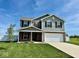 Two-story home with gray siding, brick accents, manicured lawn, and an attached two-car garage at 1112 W Nature Pointe Ln, Muncie, IN 47304