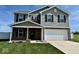 Two-story home with gray siding, brick accents, a manicured lawn, and an attached two-car garage at 1112 W Nature Pointe Ln, Muncie, IN 47304