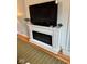 Close-up of a modern electric fireplace with a decorative mantel and flat screen television above at 1112 W Nature Pointe Ln, Muncie, IN 47304
