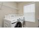 Well-lit laundry room featuring modern front load washer and dryer set with a metal storage rack at 11121 Godfrey Dr, Noblesville, IN 46060