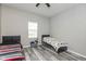 Neutral bedroom featuring two beds, laminate floors, and natural light from window at 1215 N Pershing Ave, Indianapolis, IN 46222