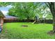 Large backyard featuring a playset, fire pit, and mature trees, perfect for outdoor activities at 1225 N Graham Ave, Indianapolis, IN 46219