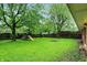 Spacious backyard featuring lush greenery, mature trees, and a playset for outdoor enjoyment at 1225 N Graham Ave, Indianapolis, IN 46219