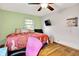 Cozy bedroom featuring hardwood floors, a ceiling fan, and a mounted TV at 1225 N Graham Ave, Indianapolis, IN 46219