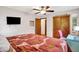 Well-lit bedroom with hardwood floors, large bed, closet, and mounted TV at 1225 N Graham Ave, Indianapolis, IN 46219