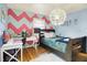 Stylish bedroom featuring a unique chevron accent wall, hardwood floors, and modern lighting at 1225 N Graham Ave, Indianapolis, IN 46219