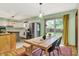 Dining area flows to kitchen with modern table and bench, plus outdoor views through sliding glass door at 1225 N Graham Ave, Indianapolis, IN 46219
