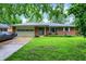 Charming brick ranch home featuring a well-manicured lawn and an attached two-car garage at 1225 N Graham Ave, Indianapolis, IN 46219