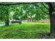 Inviting home exterior with a lush green lawn and mature trees, offering a serene setting at 1225 N Graham Ave, Indianapolis, IN 46219