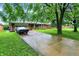 Charming front exterior with a well-manicured lawn and a long driveway, showcasing curb appeal at 1225 N Graham Ave, Indianapolis, IN 46219