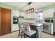 Charming kitchen featuring white cabinets, stainless steel appliances, island with seating, and modern lighting at 1225 N Graham Ave, Indianapolis, IN 46219