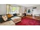 Spacious living room with hardwood flooring, area rug, and comfortable sectional sofa with throw pillows at 1225 N Graham Ave, Indianapolis, IN 46219