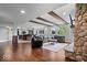 Basement living room with wooden beams, stone fireplace, and a view of the basement kitchen at 12399 Lynnwood Blvd, Carmel, IN 46033