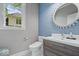 Charming powder room with blue accents, decorative mirror, and modern vanity at 12399 Lynnwood Blvd, Carmel, IN 46033